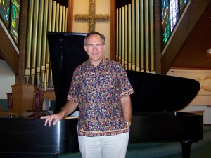 Dr. Joseph Holt in front of new Steinway Concert Grand piano at Faith Lutheran Church.